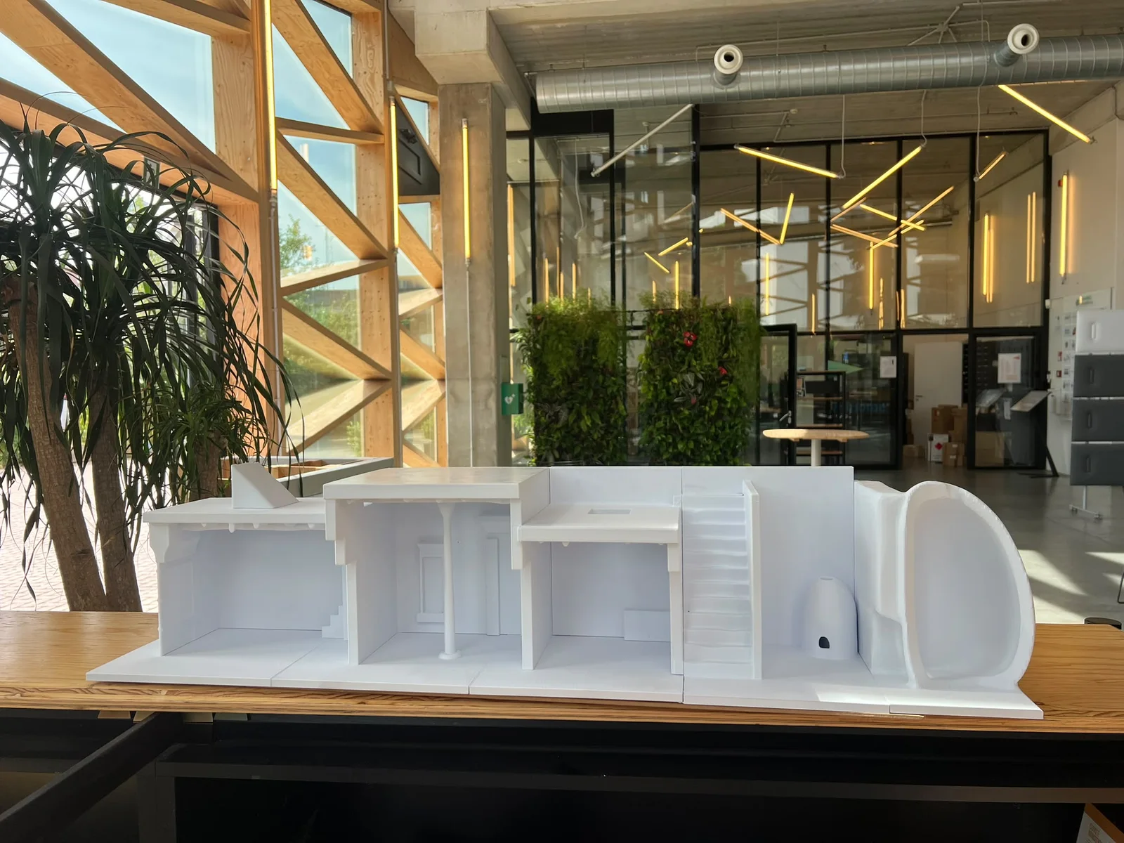 White 3D printed architectural model displayed in a modern workspace